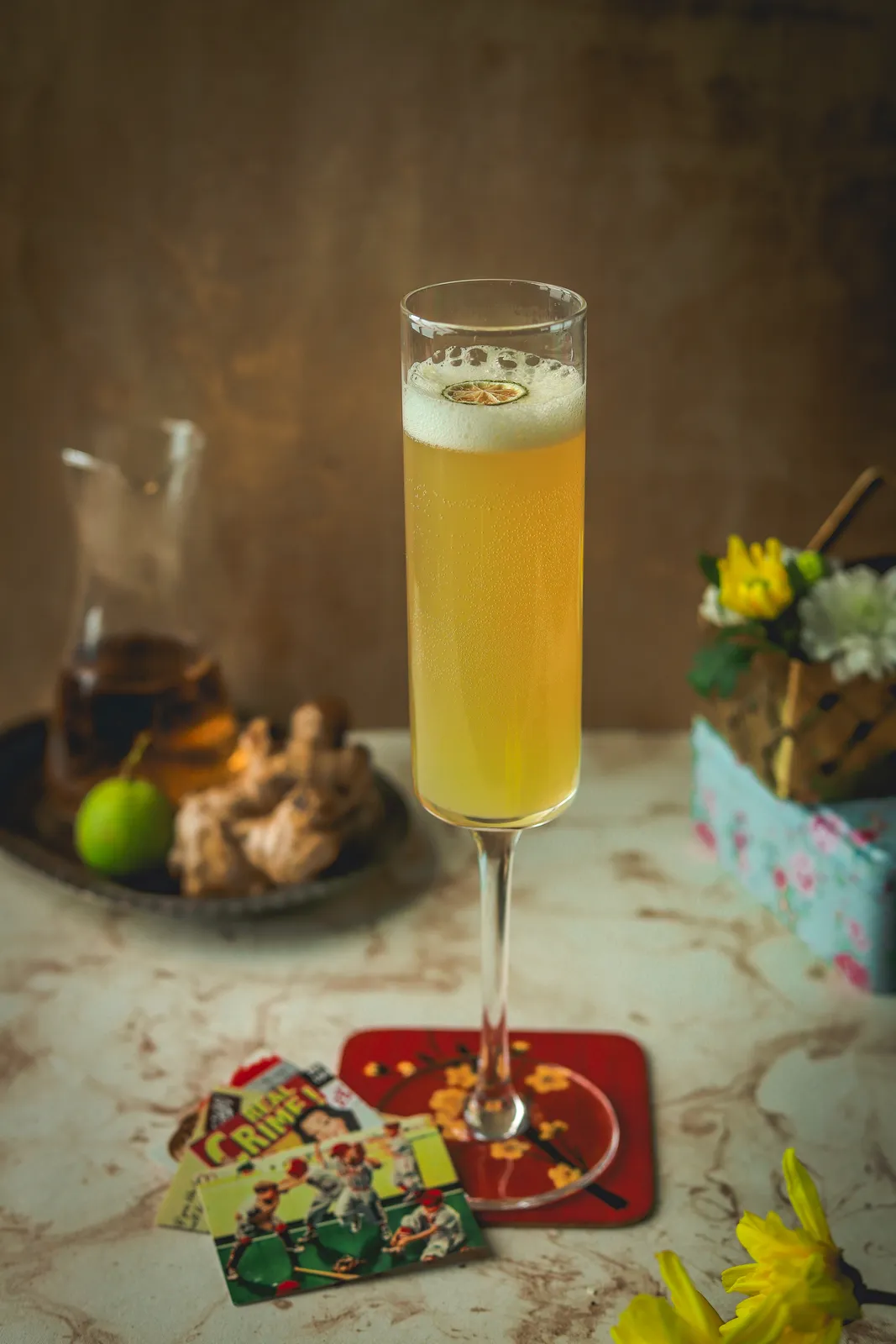 A tall yellow cocktail in a flute glass.