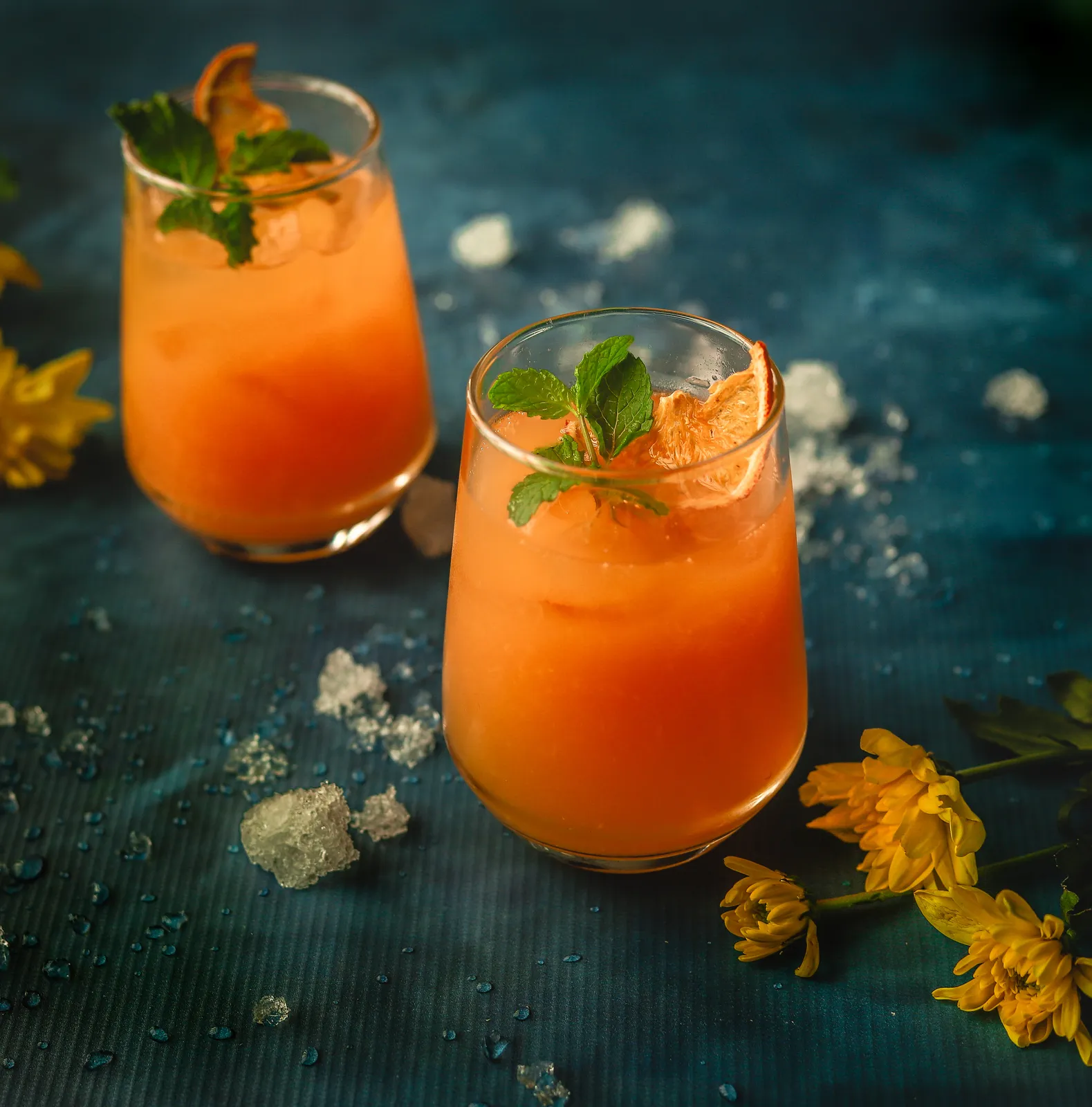 A geometric red cocktail with floral garnish.